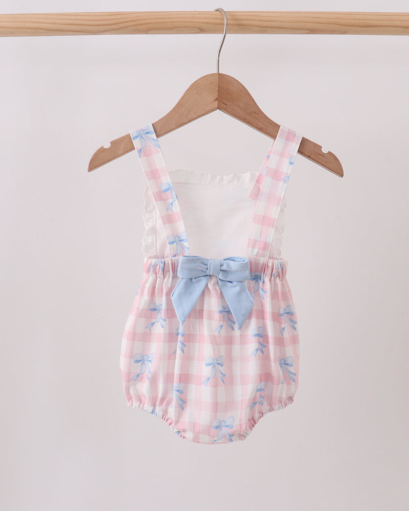 Baby romper with floral pattern and blue bow on a hanger against a white background