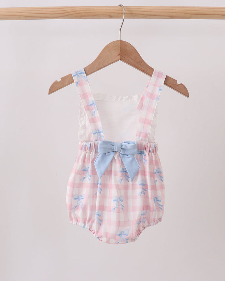 Baby romper with floral pattern and blue bow on a hanger against a white background