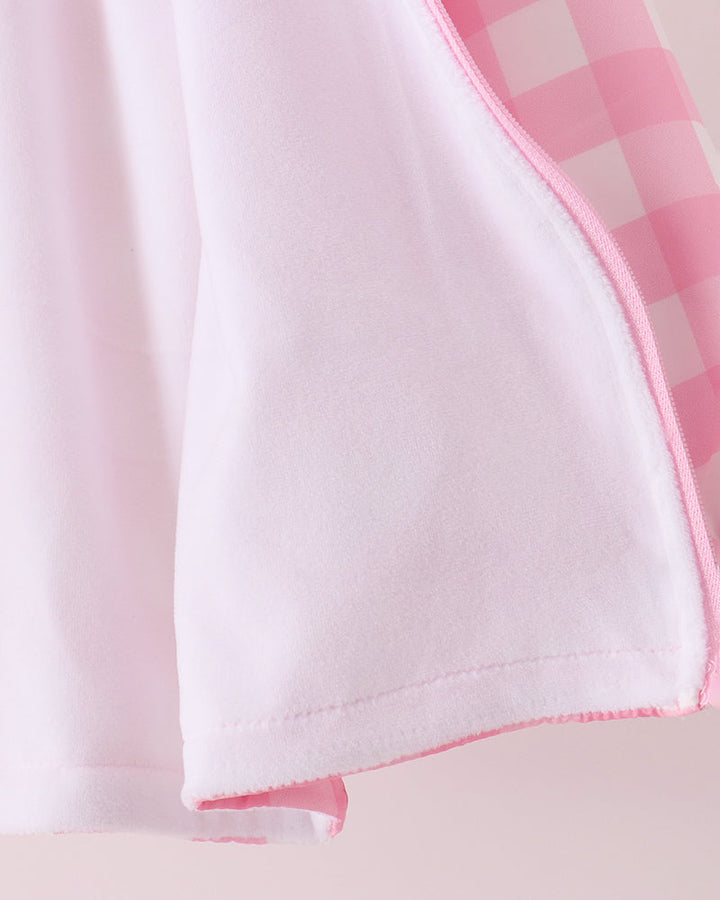 Pink gingham raincoat lower hem with pink stitched edging
