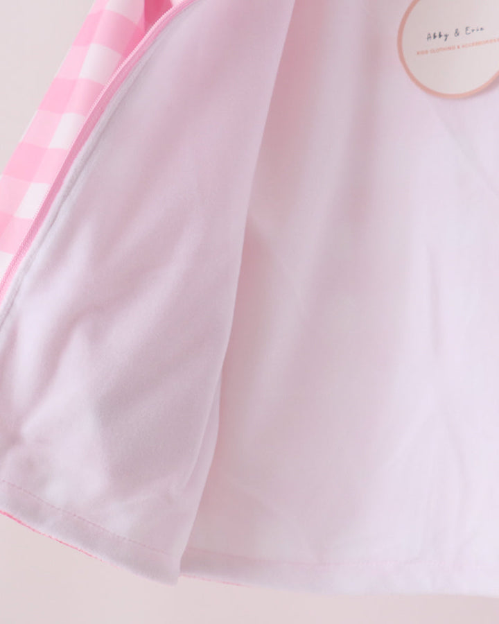 Pink gingham raincoat side panel with smooth fabric and stitched edge