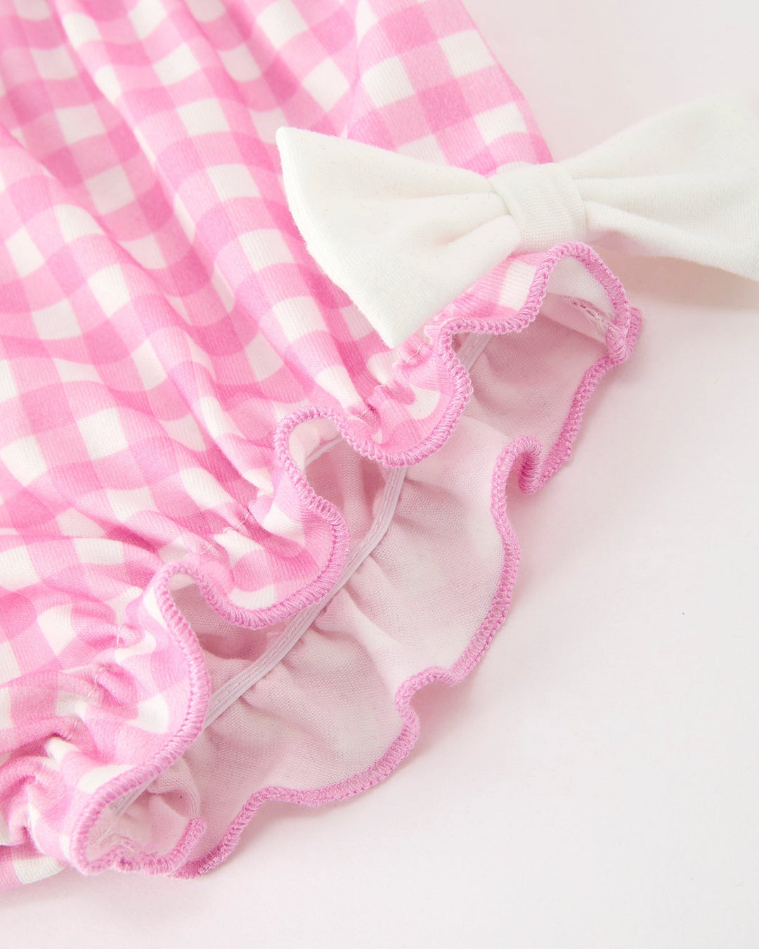 Girls pink gingham bloomers with ruffled edges and bow accent at side