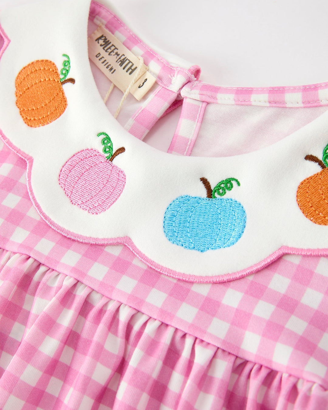 Girls gingham dress with stitched pumpkin, apple, and berry motifs at neckline