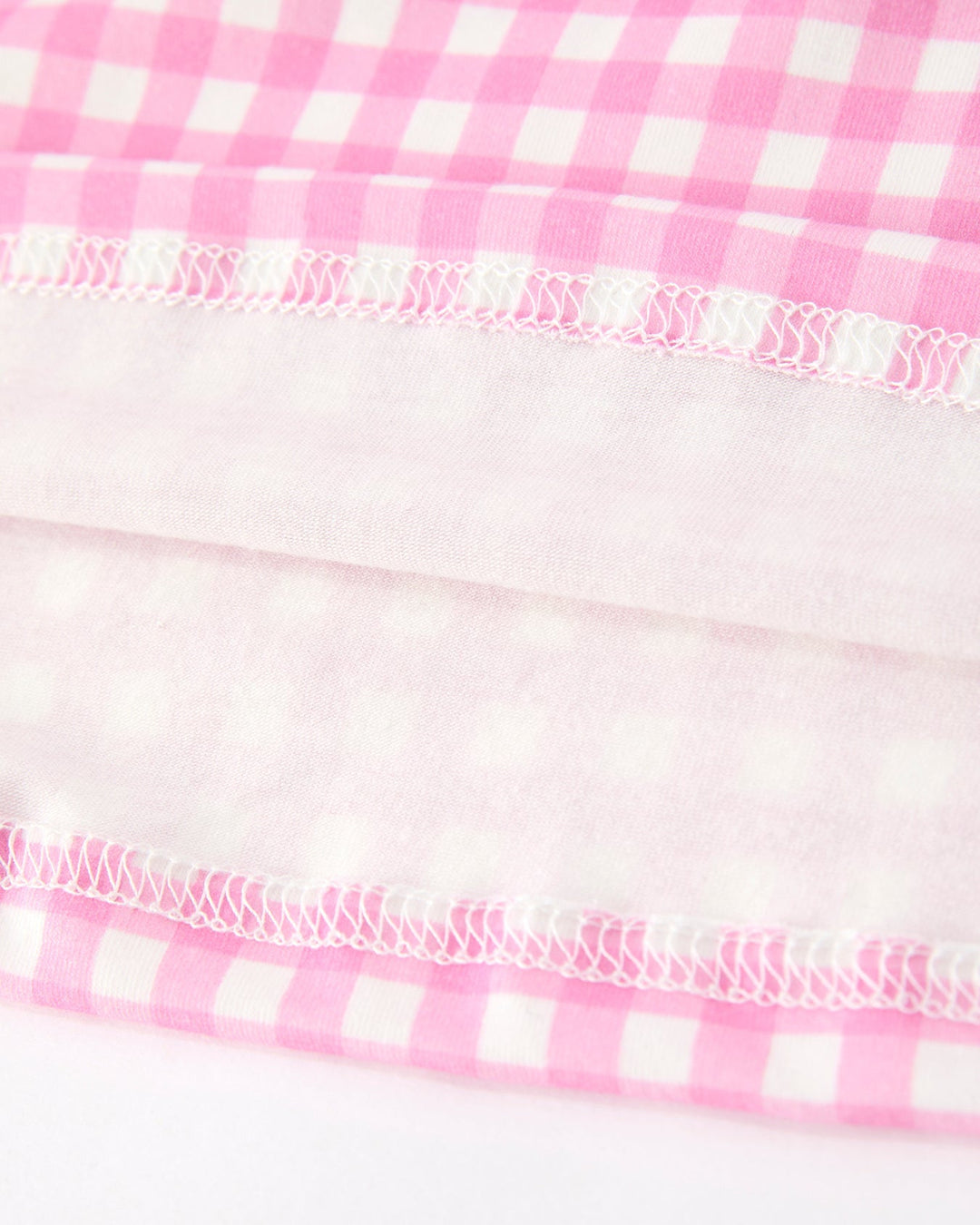 Girls pink gingham dress hem with ruffled elastic trim and gathered stitching