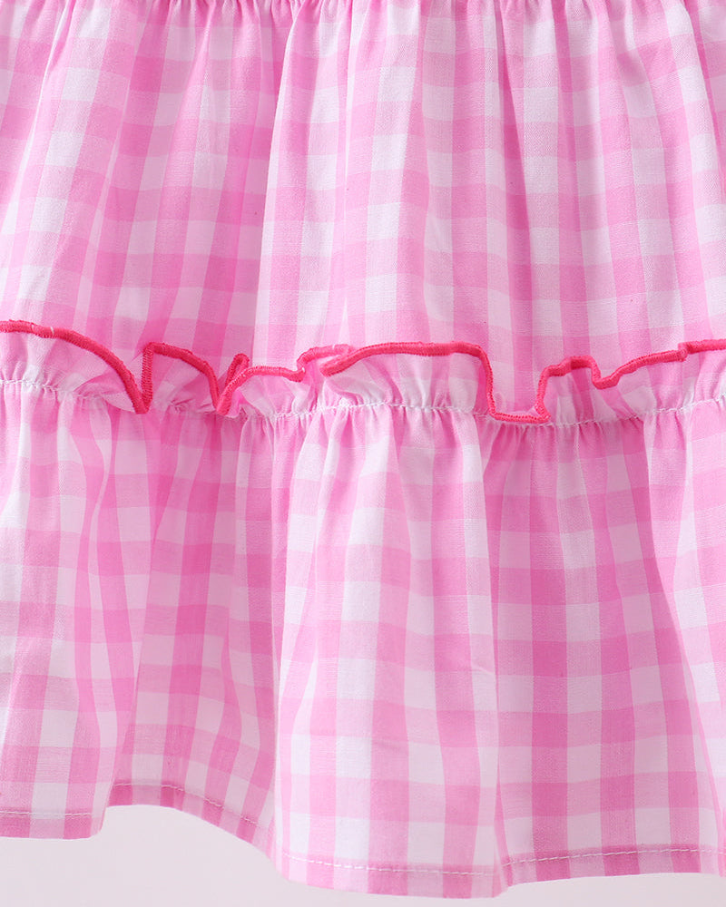 Close-up of a pink and white checkered skirt with pink trim on a white background