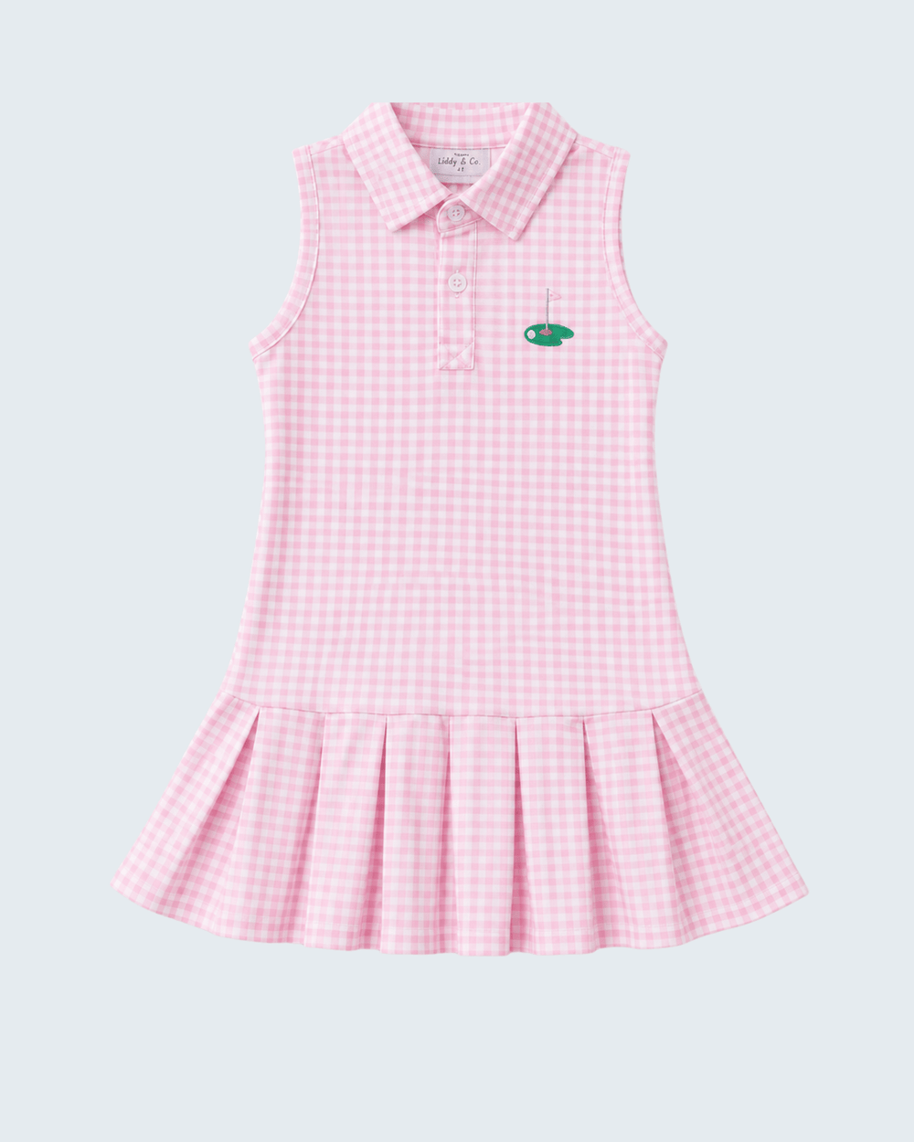A sleeveless pink and white gingham polo dress for girls, featuring a small green embroidered fish logo on the left chest, set against a solid light gray background.