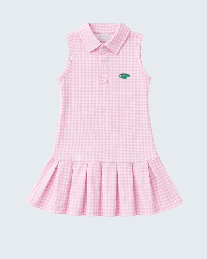 A sleeveless pink and white gingham polo dress for girls, featuring a small green embroidered fish logo on the left chest, set against a solid light gray background.