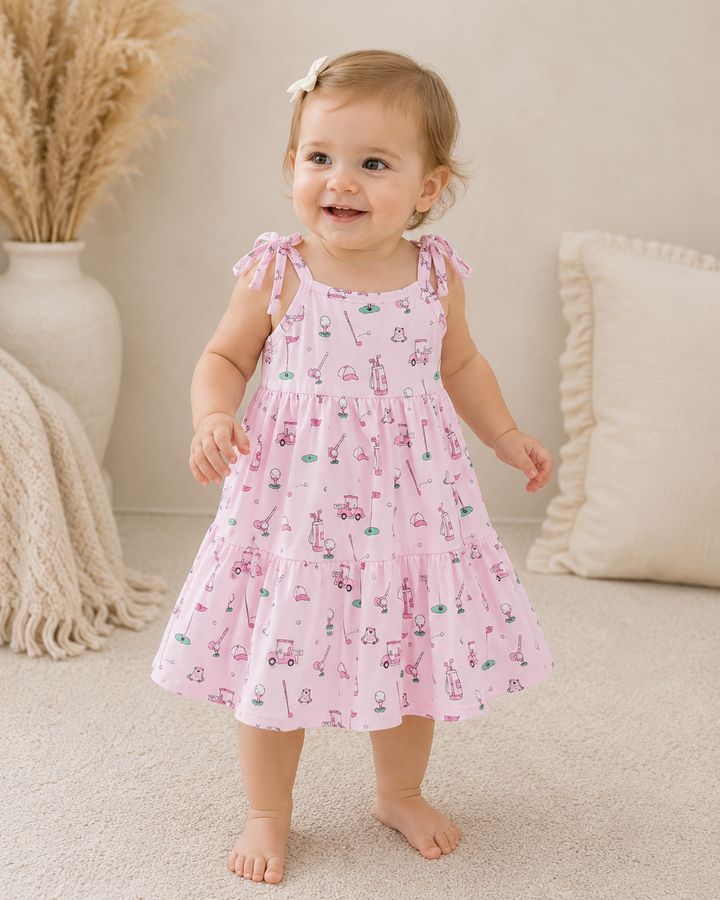 Baby girl in living room wearing Pink Golf Print Tiered Dress