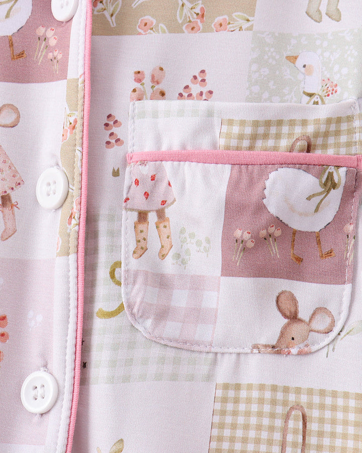 White pajama top with pink trim, round buttons, and patchwork chest pocket