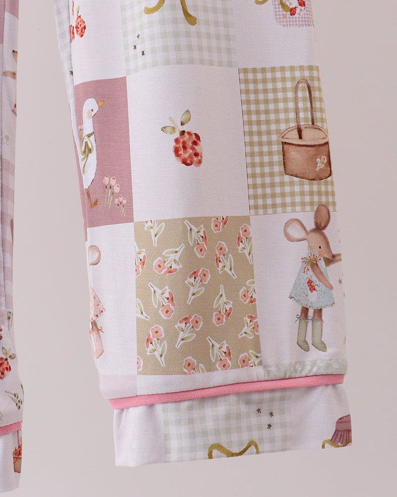 Pink and white patchwork pajama pants with printed motifs and elastic cuffs