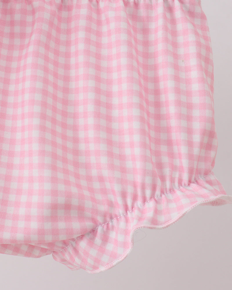 Pink and white checkered baby romper on a light gray background