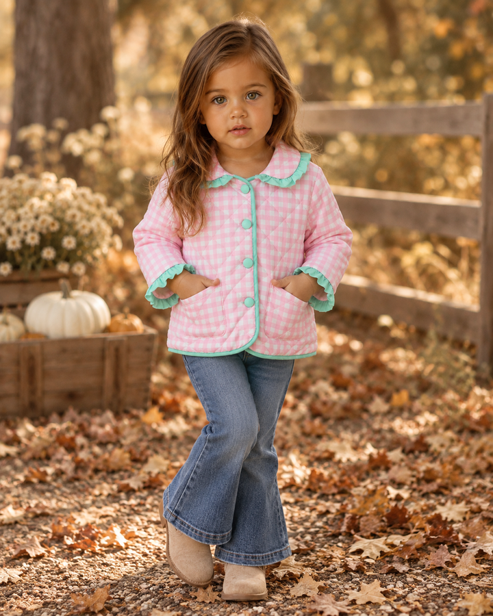 Pink gingham ruffle jacket with turquoise cuffs, collar, and button front worn