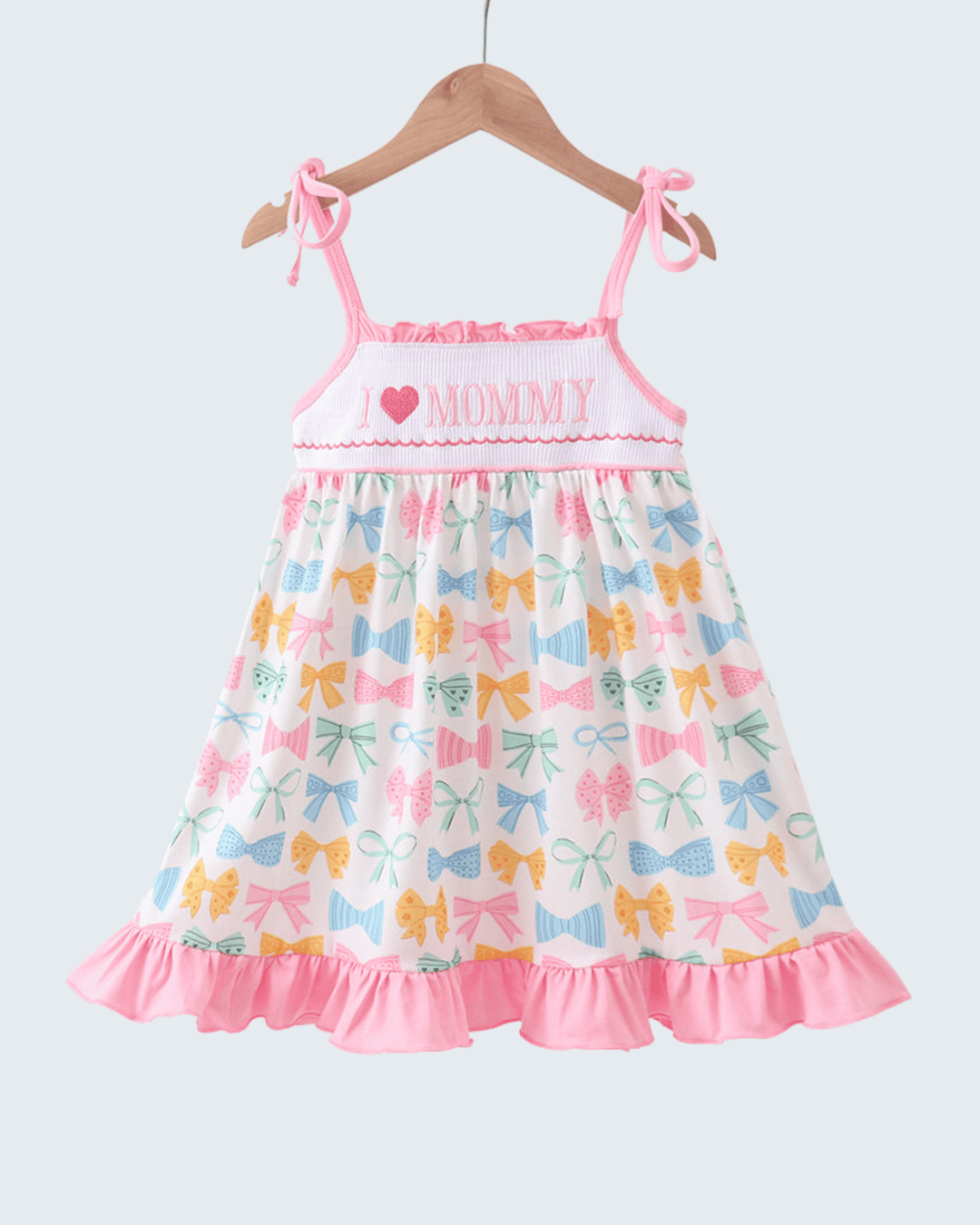 Children's dress with colorful bow pattern and 'Mommy' text on a white background