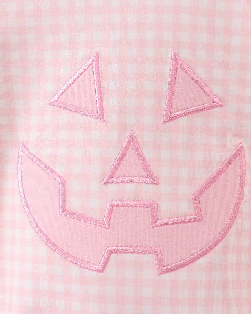 Close-up of pink gingham jack-o-lantern applique with stitched outline on front