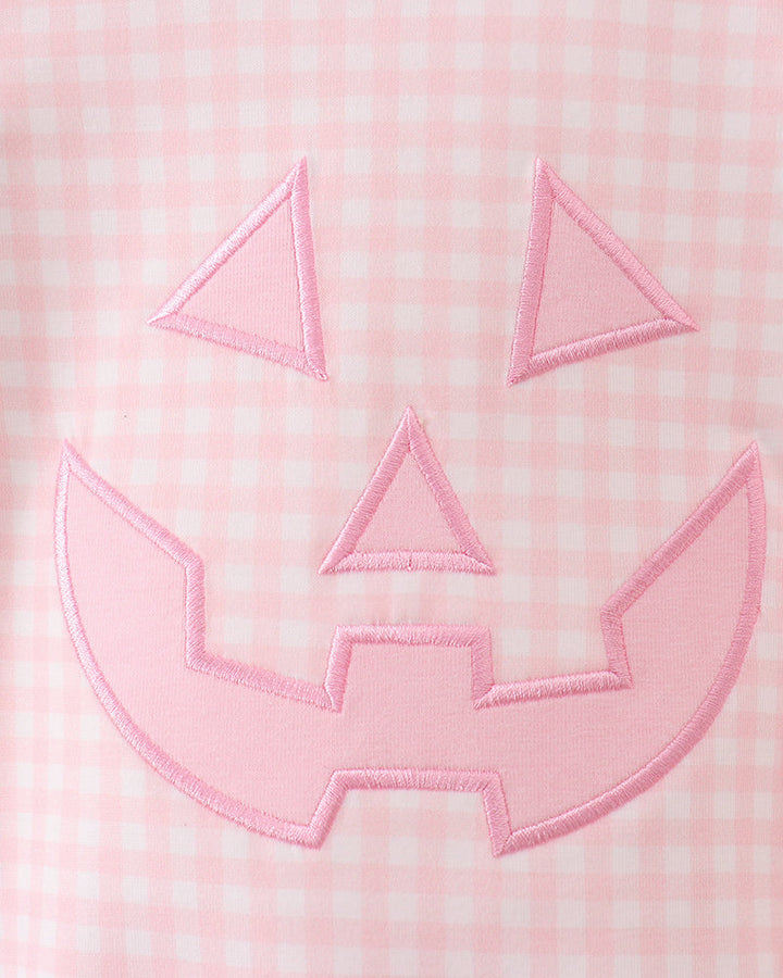 Close-up of pink gingham jack-o-lantern applique with stitched outline on front