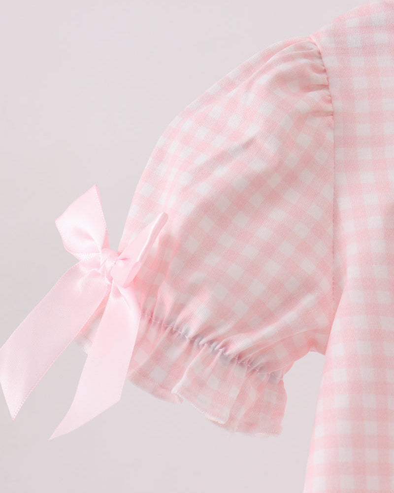 Pink gingham bubble romper sleeve with white bow detail on the shoulder