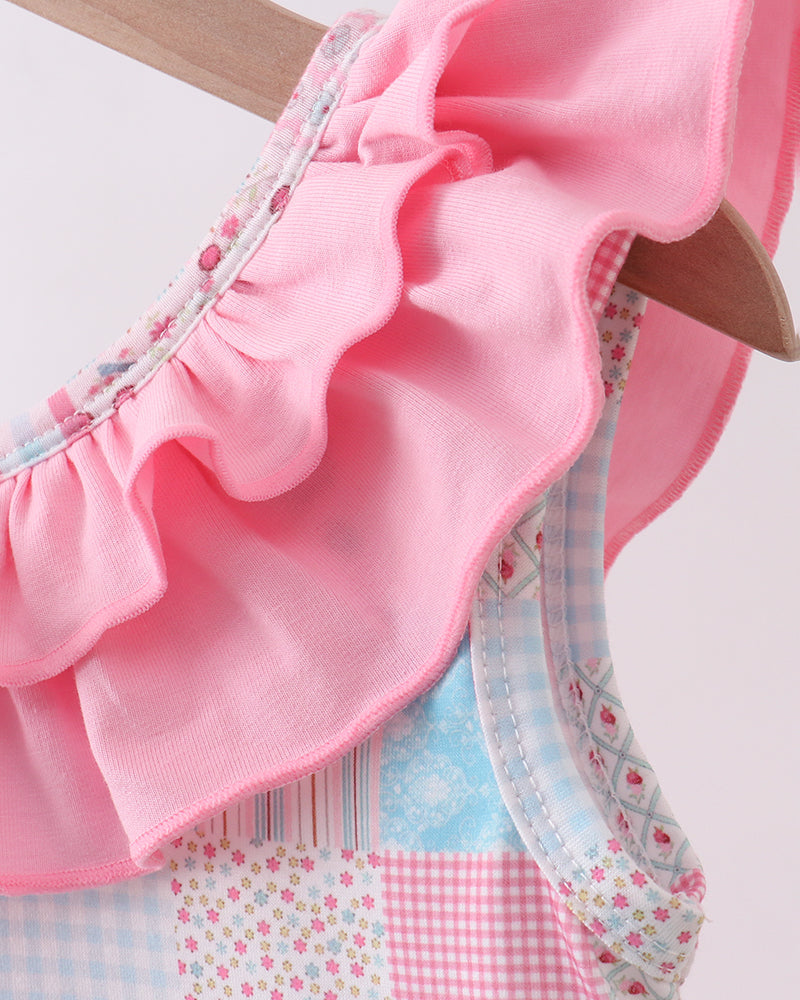 Pink ruffled garment with a patchwork pattern on a white background