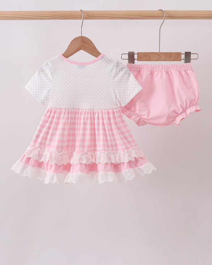 Pink top and bloomer set with embroidered details, ruffled skirt, and lace-trim hems