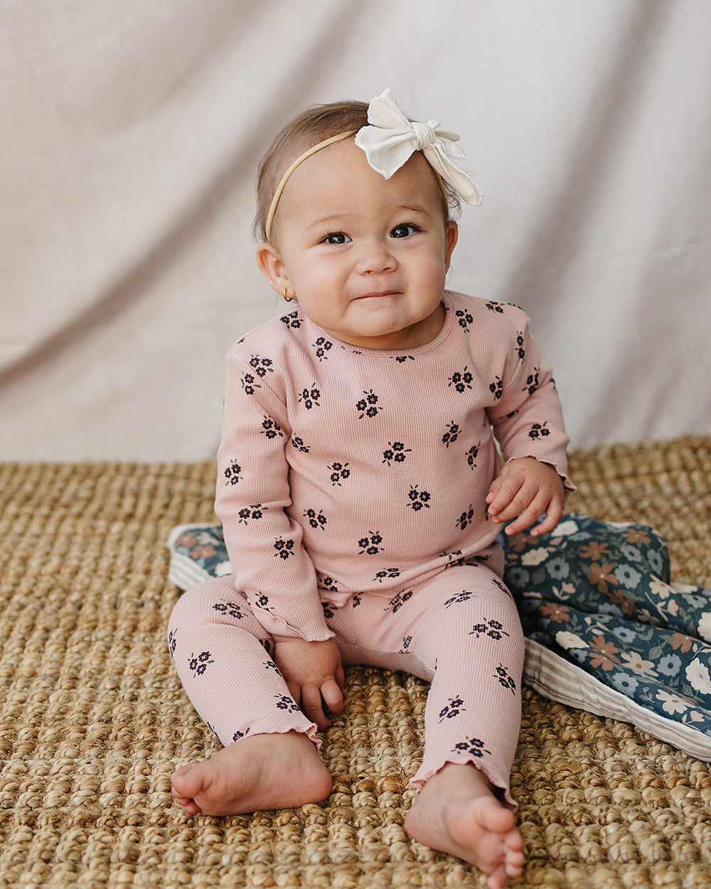 Pink cotton pajama set with small flower print on baby, long sleeves and pants