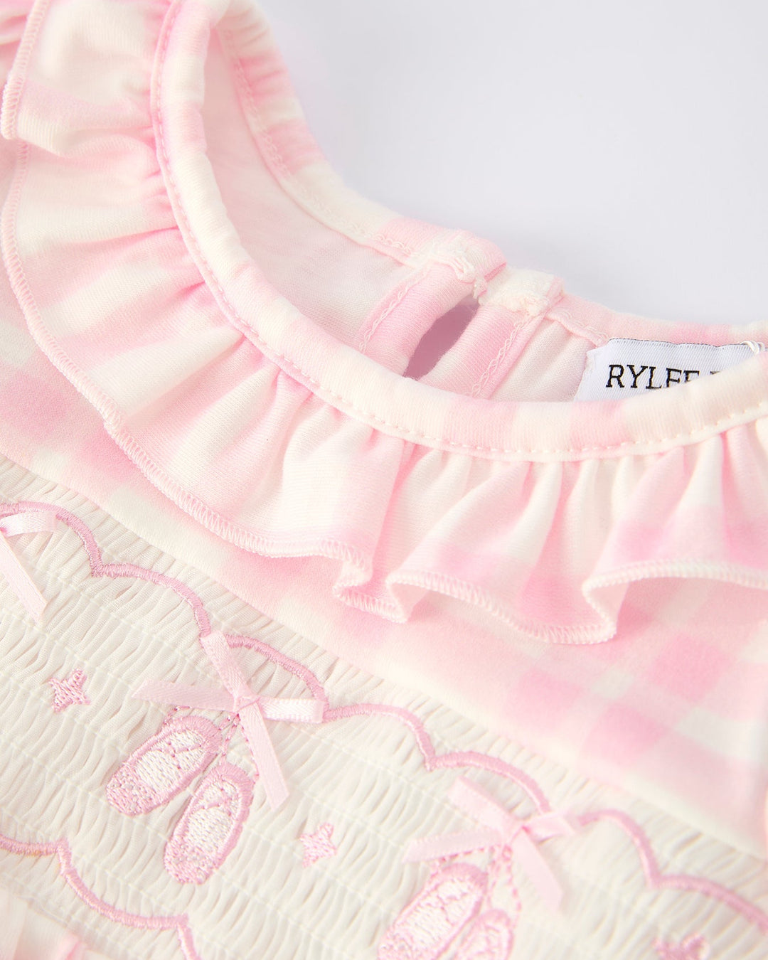 Pink plaid romper with layered ruffle collar and heart-style embroidery on chest