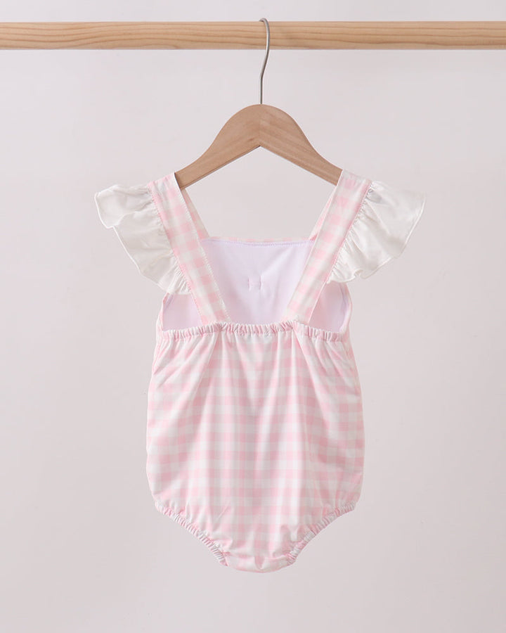 Pink and white striped baby romper on a wooden hanger against a light gray background