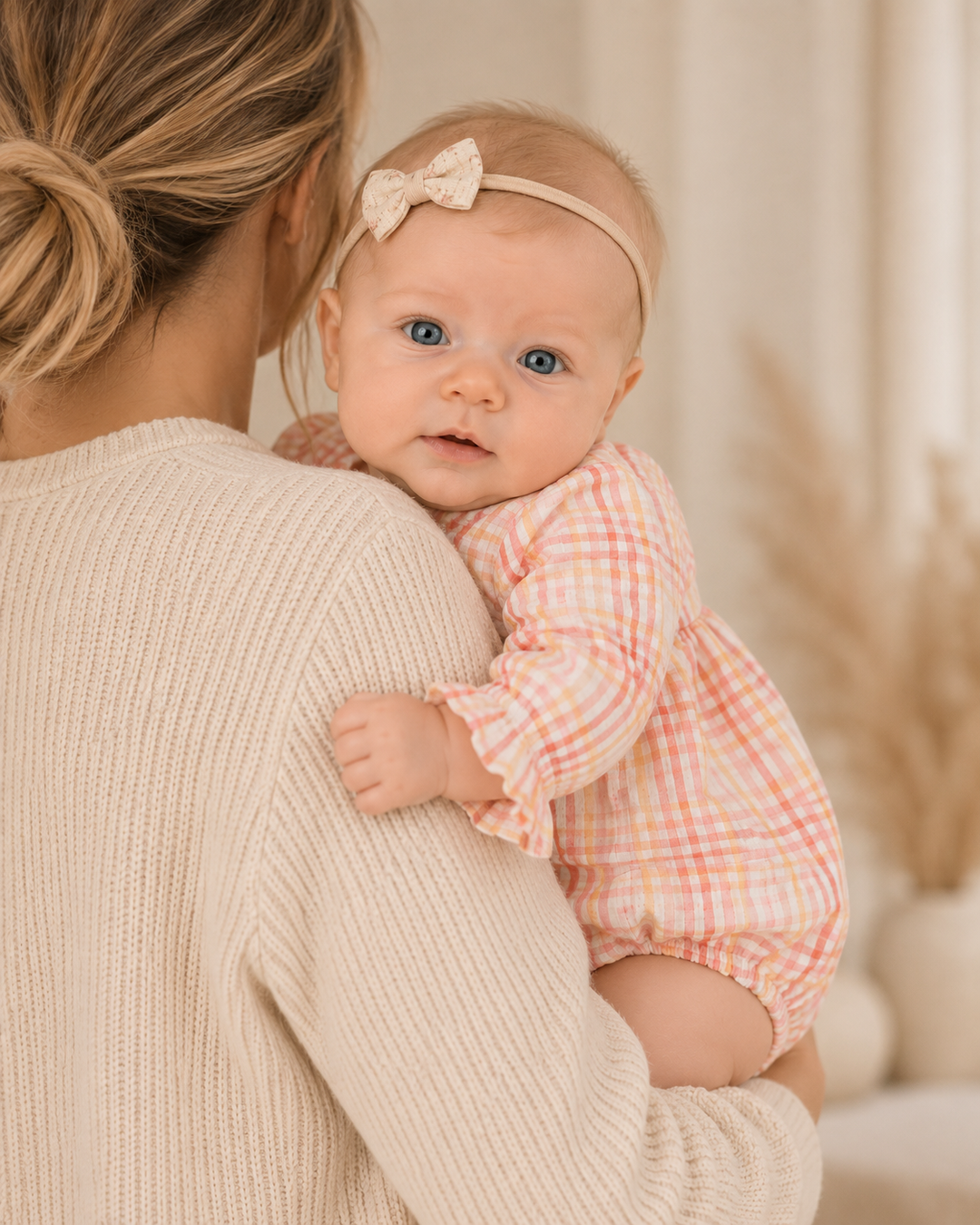 Baby wearing pink plaid long sleeve bubble romper with gathered waist