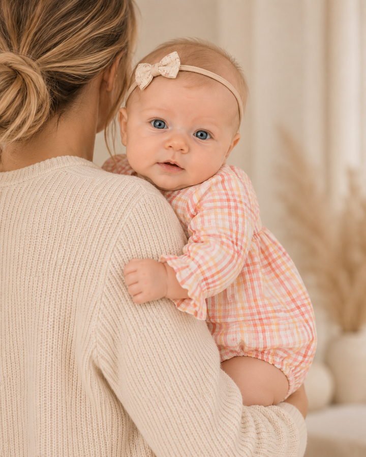 Baby wearing pink plaid long sleeve bubble romper with gathered waist