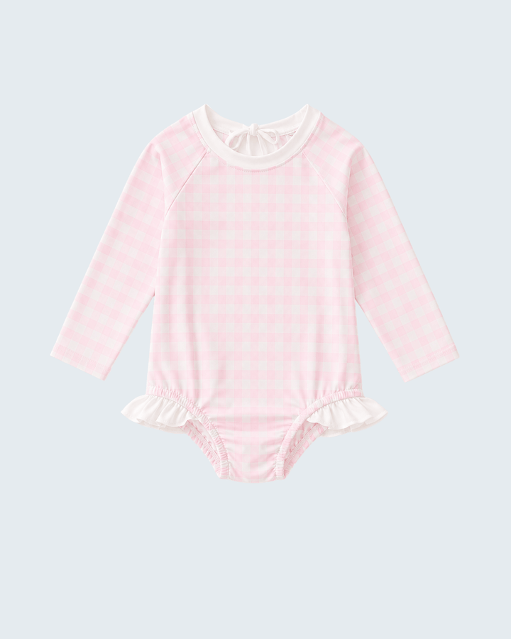 Pink rashguard with ruffled details on a light gray background