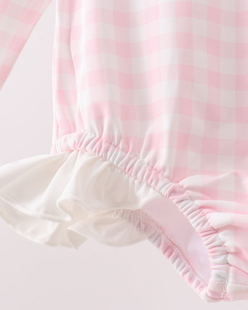 Close-up of pink and white striped fabric with ruffled edge on a light background
