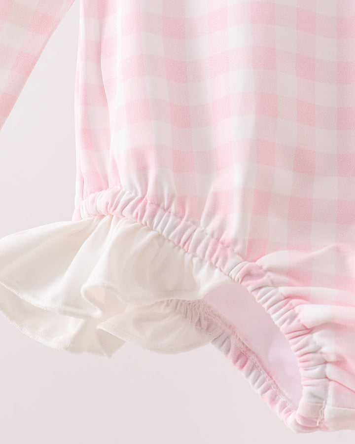 Close-up of pink and white striped fabric with ruffled edge on a light background