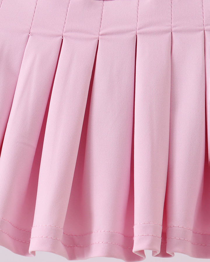 Close-up of a pink pleated skirt on a light gray background