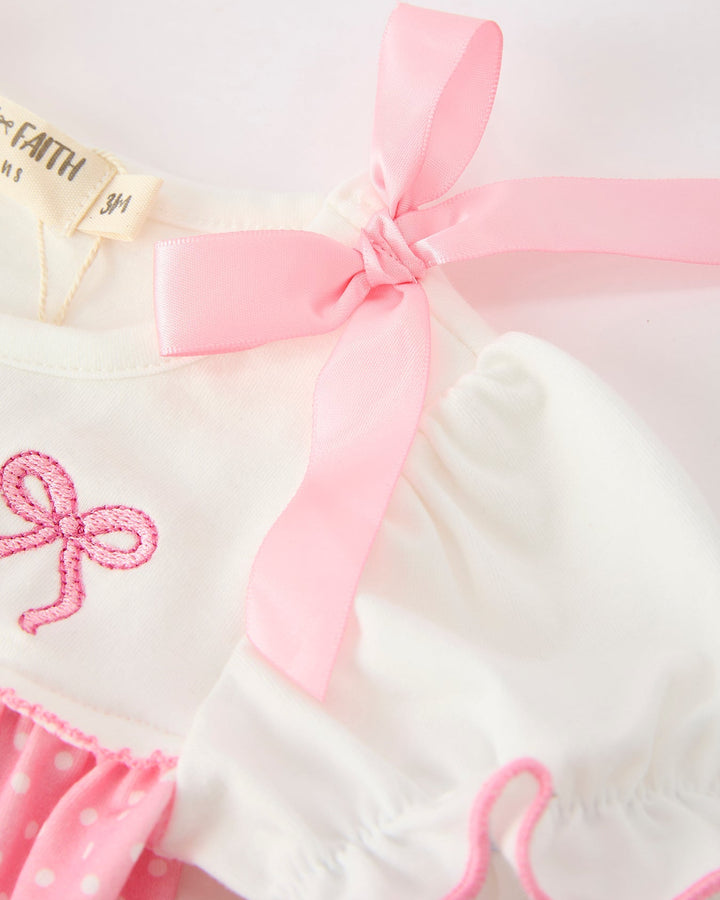 White bubble romper with large pink bow at neckline and soft puff sleeves