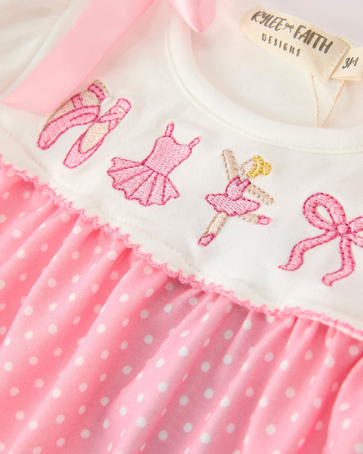 White romper with pink embroidered ballet dancers and a pink polka-dot skirt