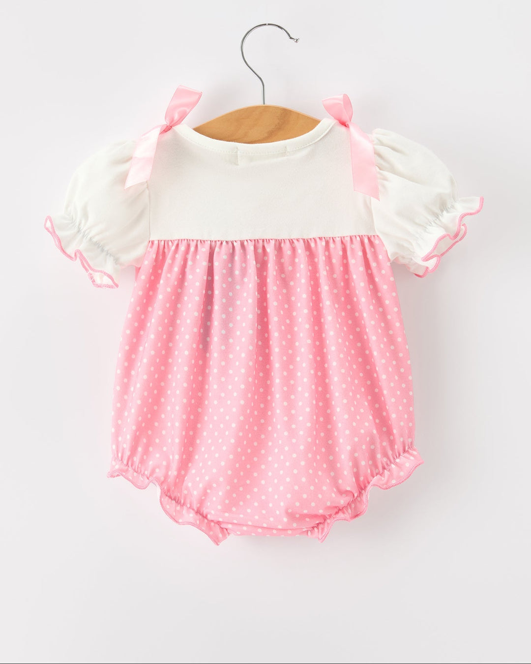 Pink polka-dot bubble romper with white puff sleeves and pink side ribbon bows