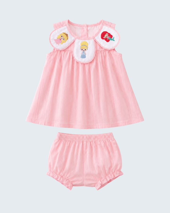 Pink baby dress and bloomers set with character patches on a light gray background