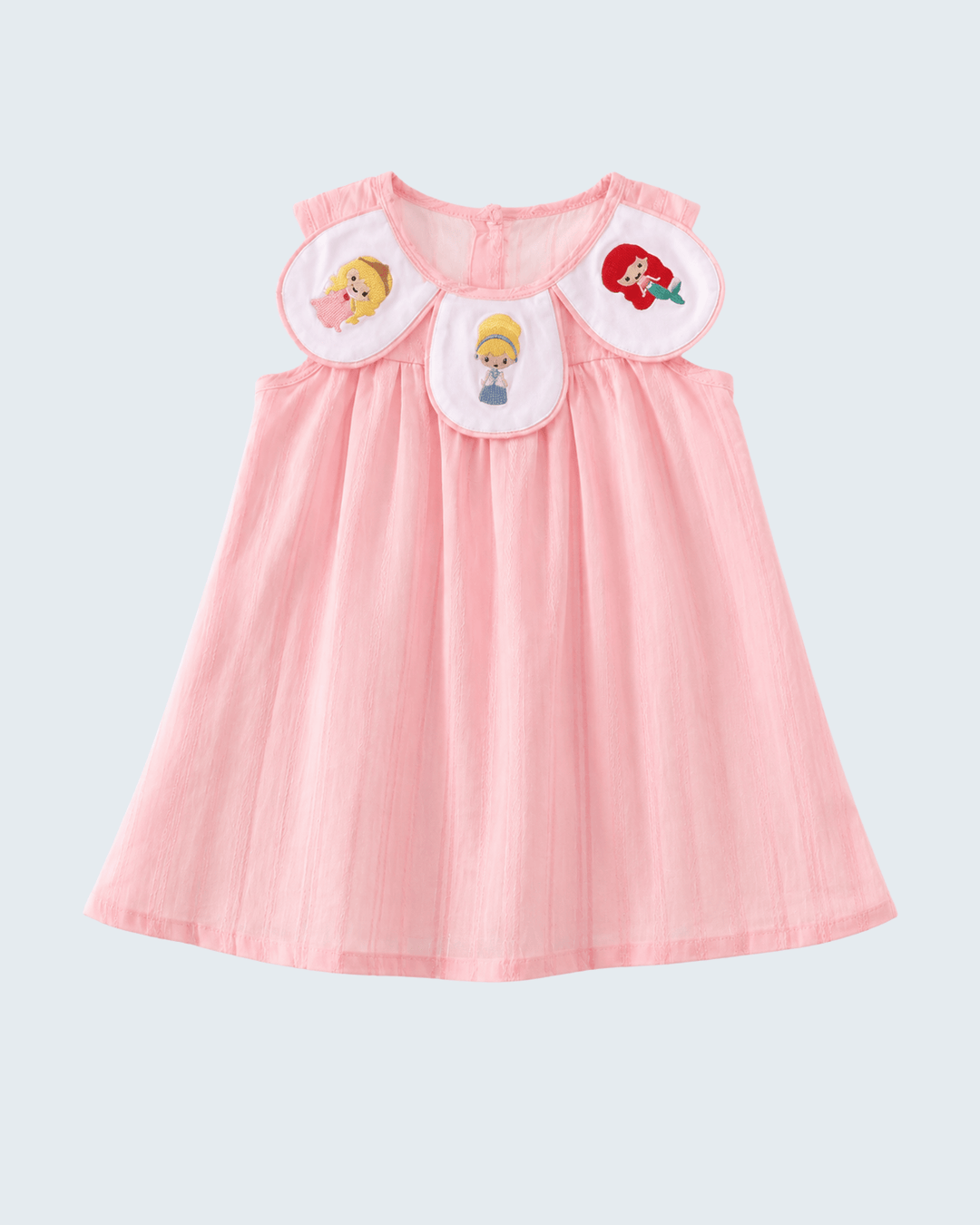 Pink dress with cartoon character patches on a light gray background
