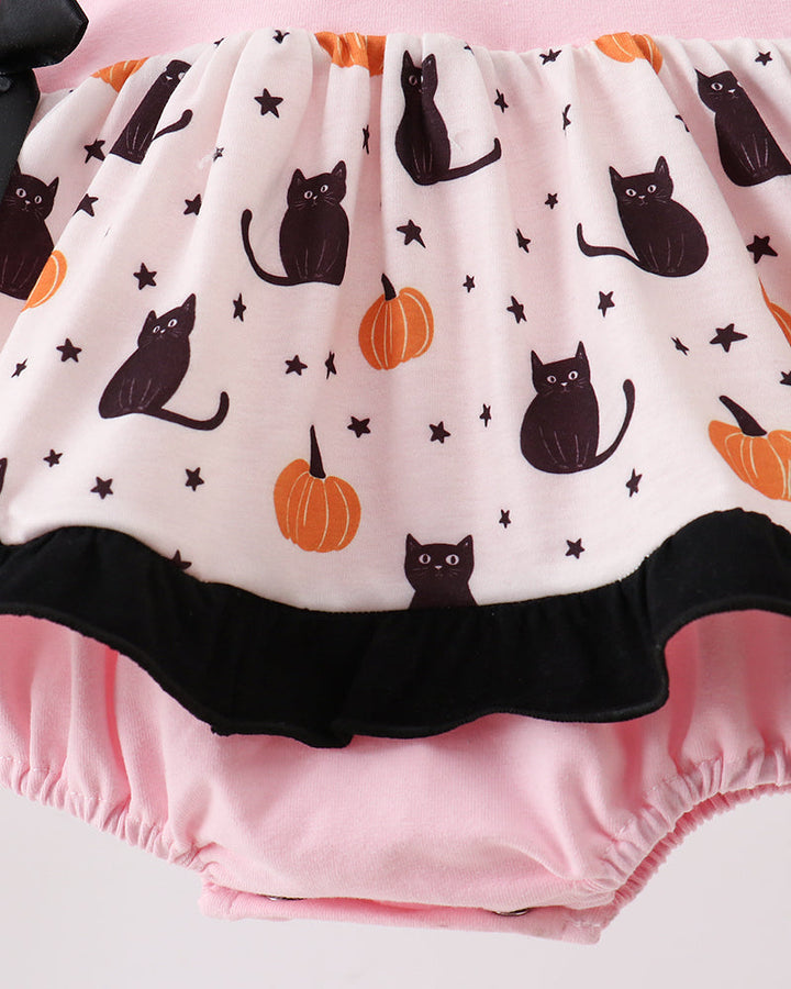 A close-up of a baby bloomers with a Halloween print. The top fabric is off-white with a pattern of black cats, orange pumpkins, and small black stars, finished with a black ruffle trim.