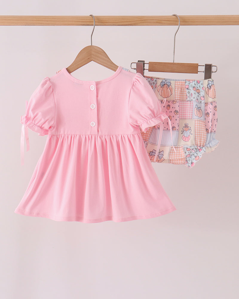 Pink embroidered ruffle dress with pumpkin print bloomer set on hangers
