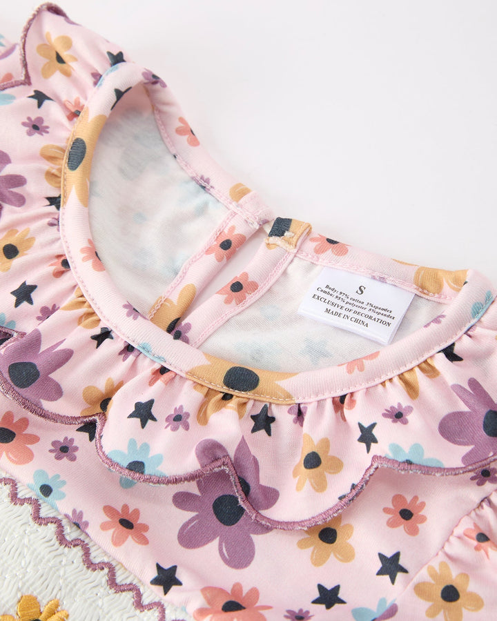 Girls light pink dress neckline with colorful floral and star print, scalloped trim