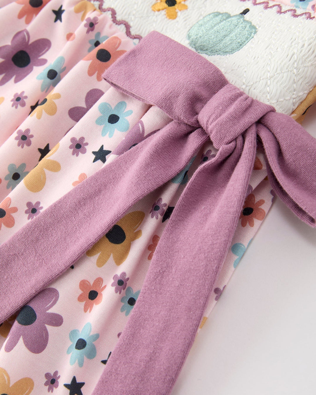 Girls light pink dress with floral and star print, gathered waist and lavender tie bow