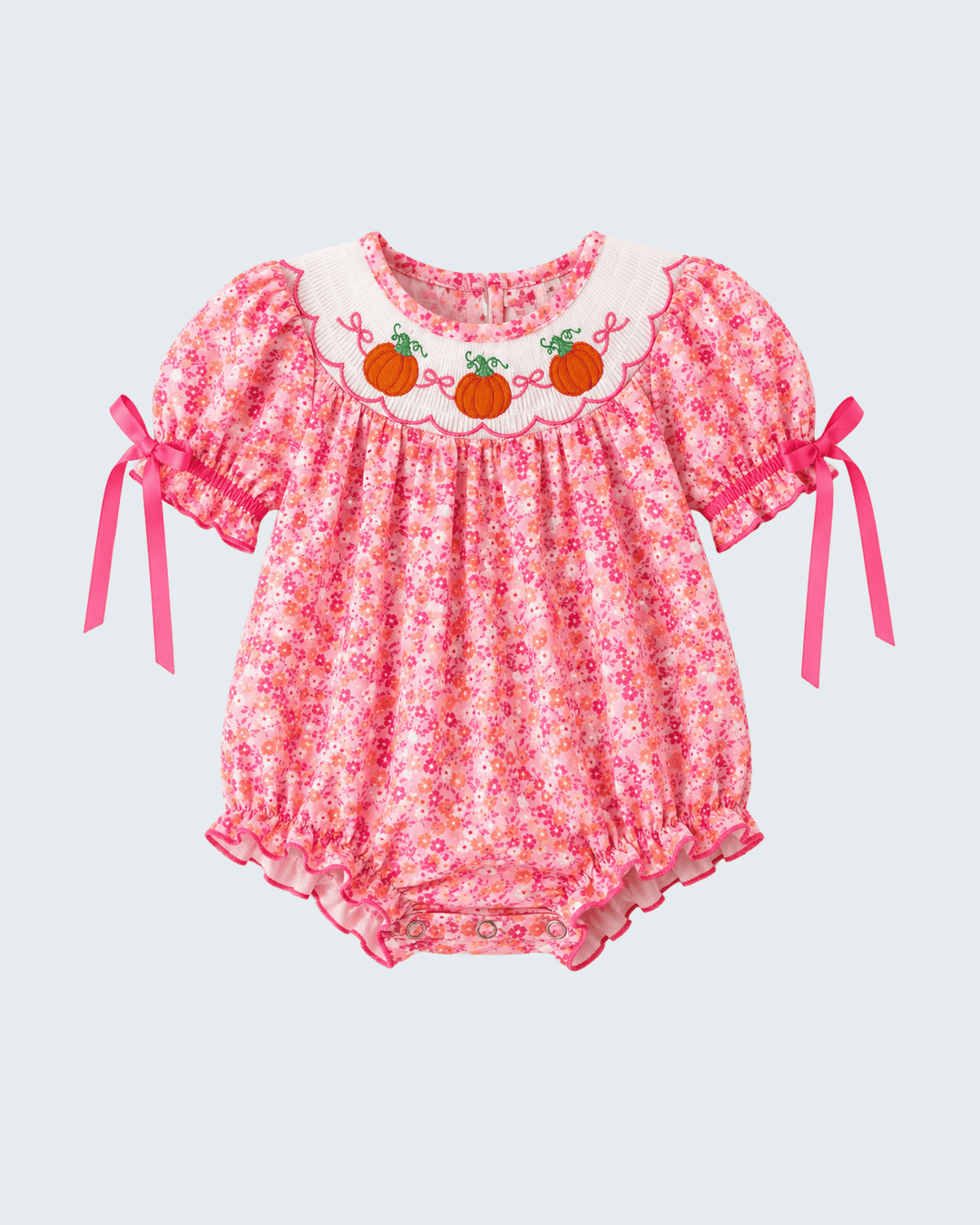 Pink floral smocked bubble romper with ruffled trim and tie sleeves