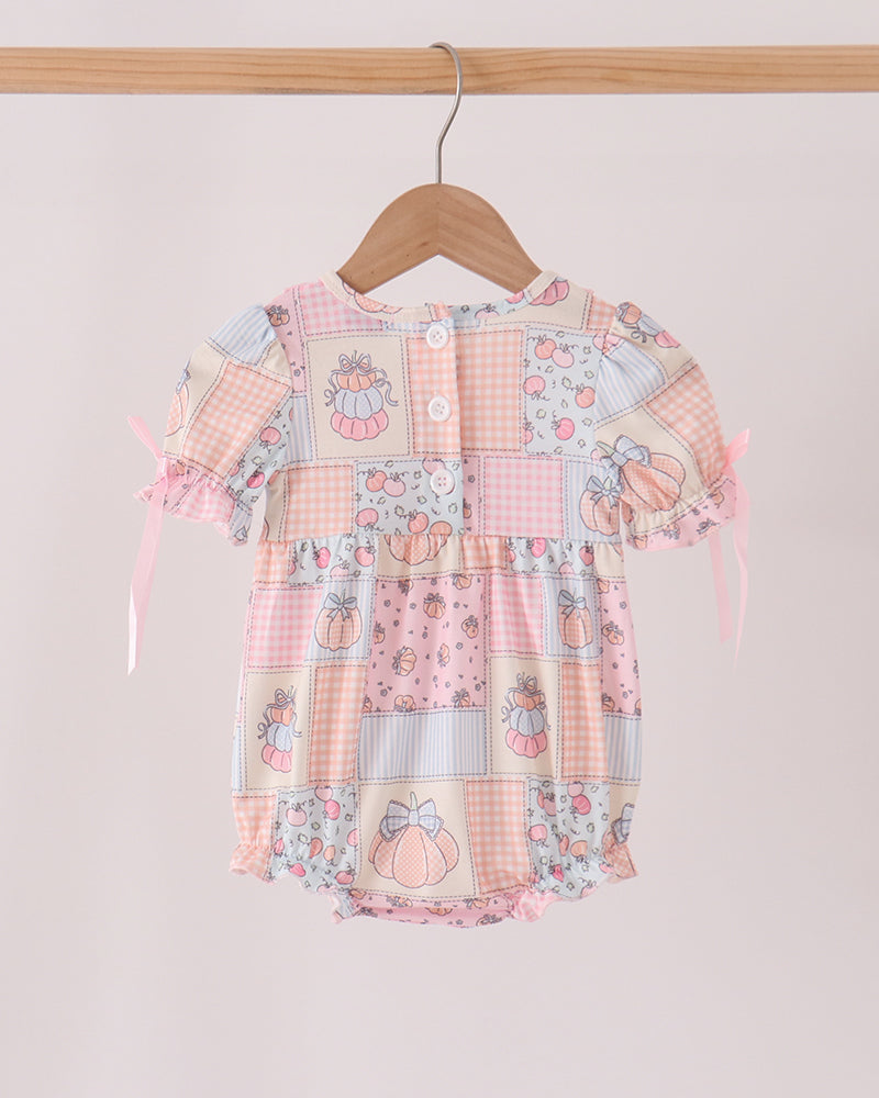 Orange-pink patchwork bubble romper with button front and ruffled cap sleeves