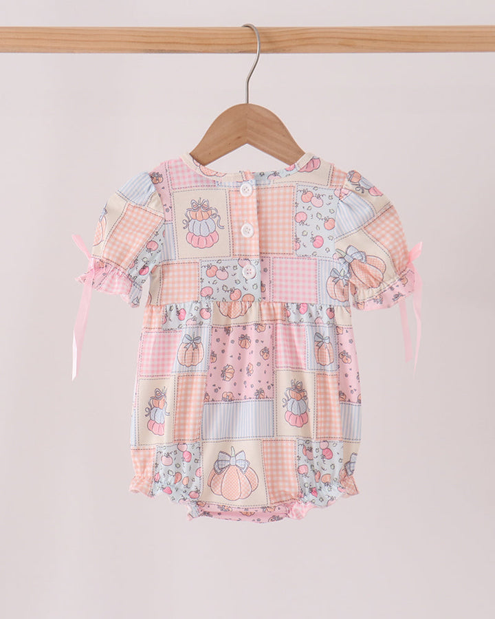 Orange-pink patchwork bubble romper with button front and ruffled cap sleeves