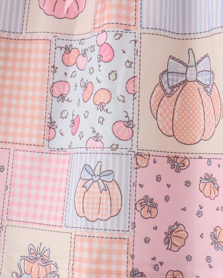 Pink patchwork print fabric with pumpkin motifs and patch square pattern