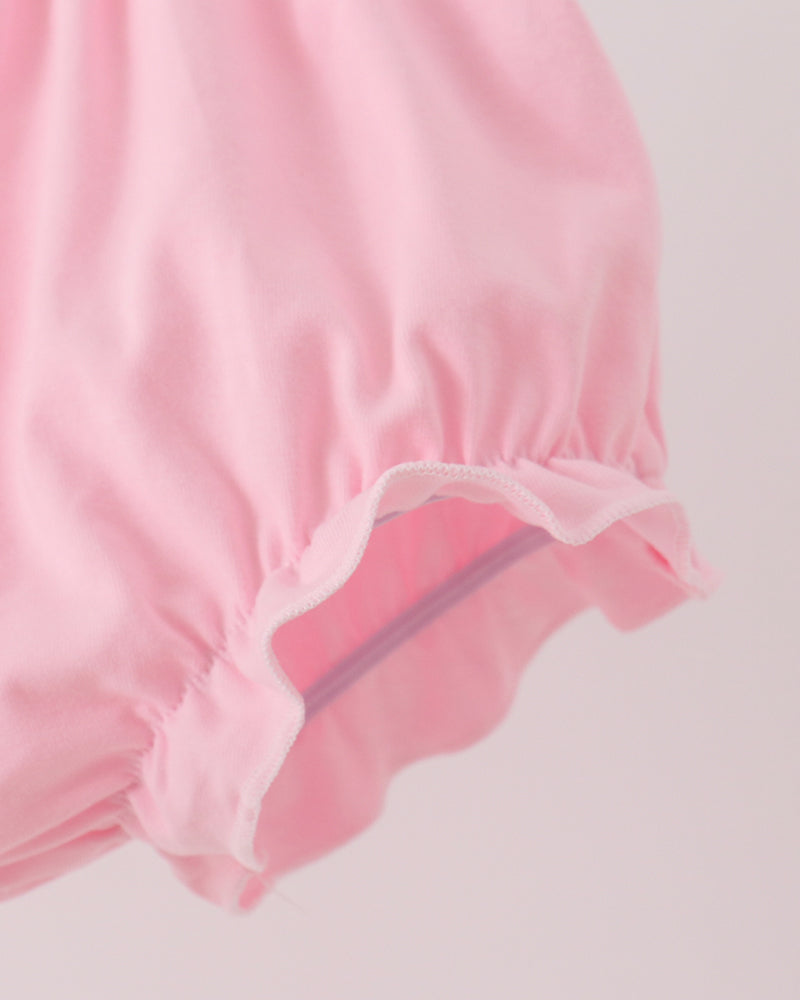 Pink bloomer shorts with elastic leg openings and gathered ruffle hem