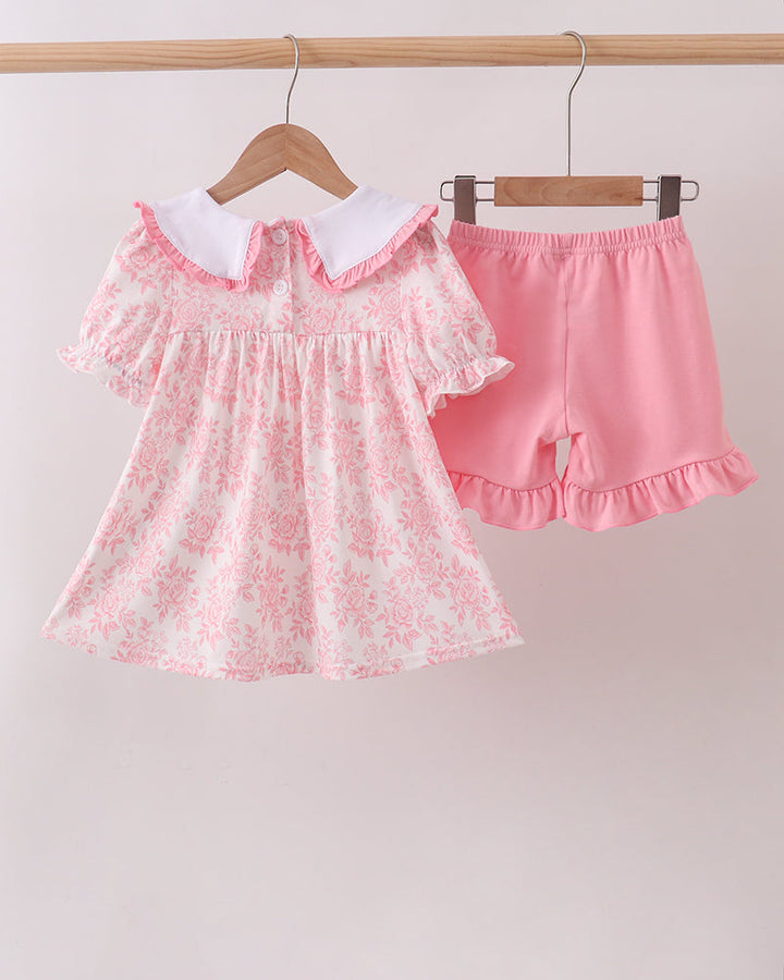Pink floral ruffle dress set with matching pink shorts on hangers
