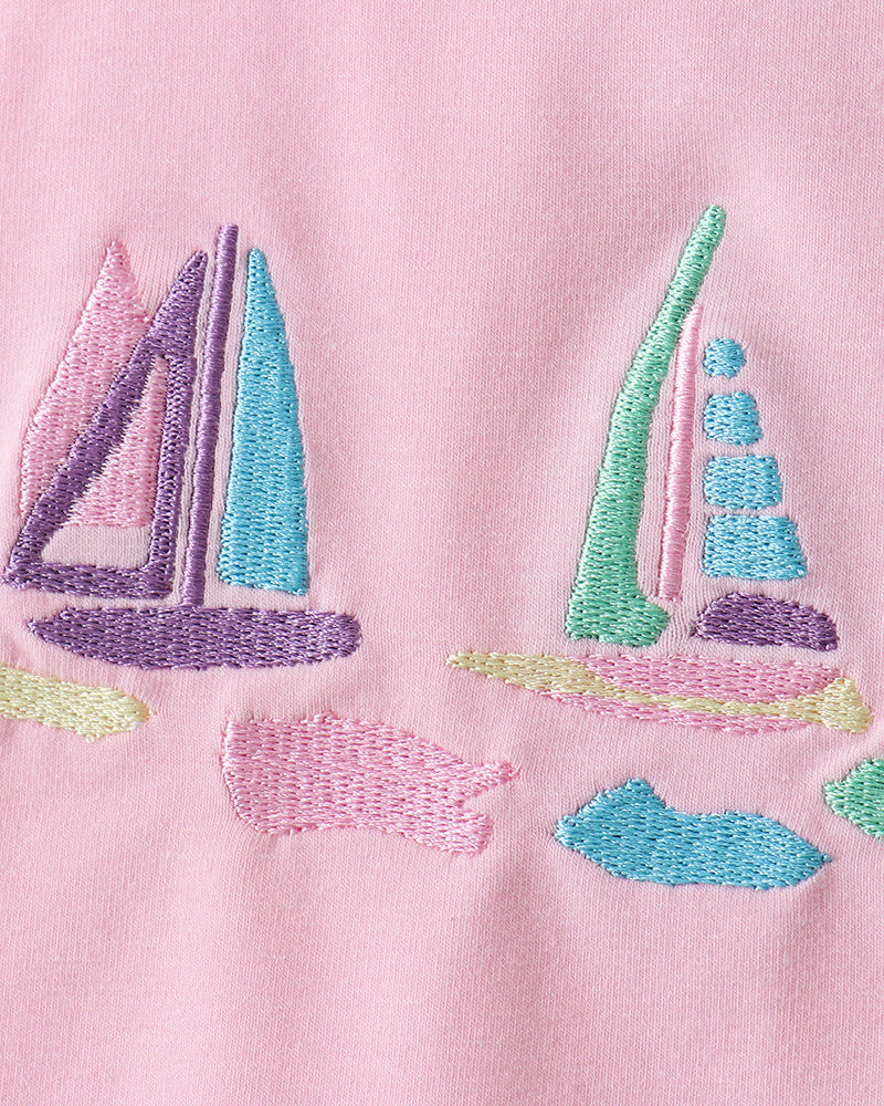 Close up of sailboat embroidery on pink fabric