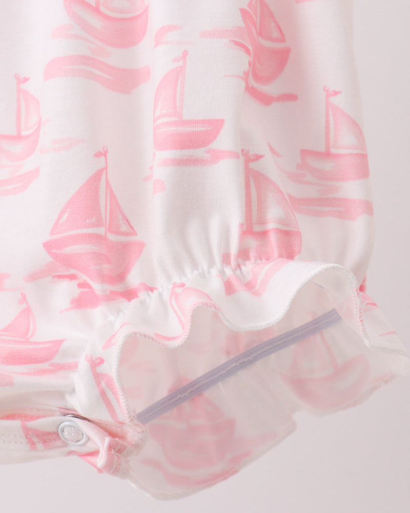 Baby romper with pink sailboat pattern on a white background