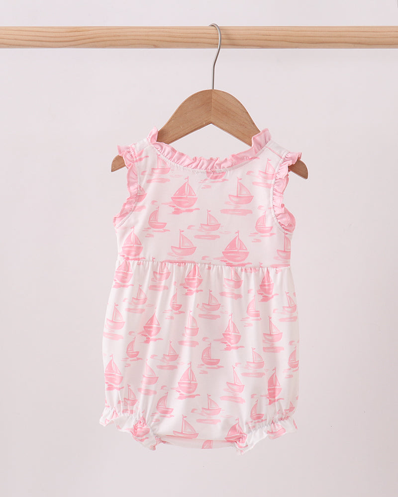 Baby bubble with pink sailboat pattern on a wooden hanger against a white background