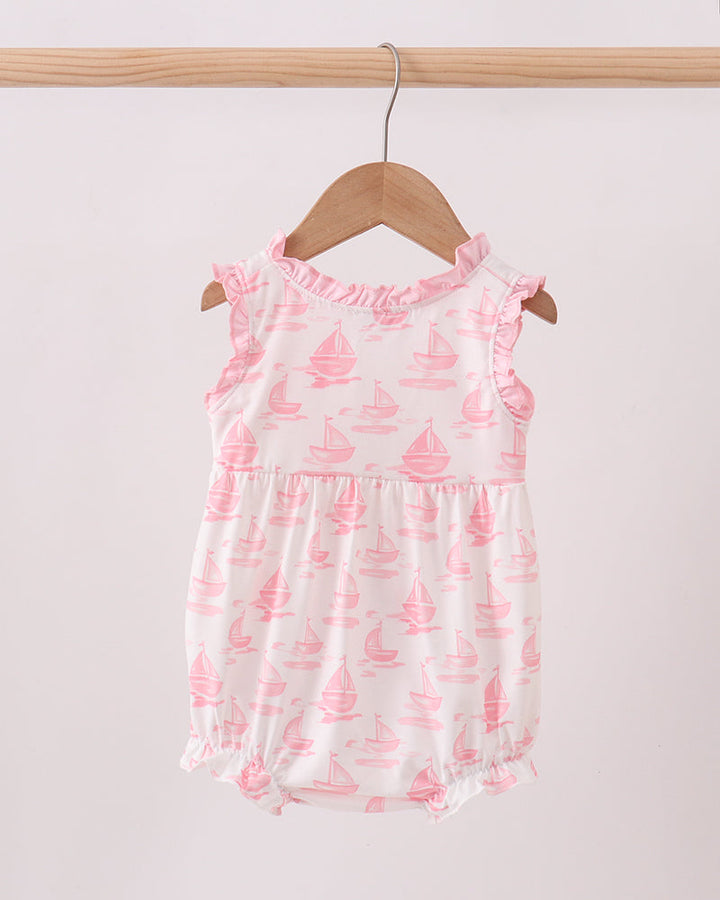 Baby bubble with pink sailboat pattern on a wooden hanger against a white background