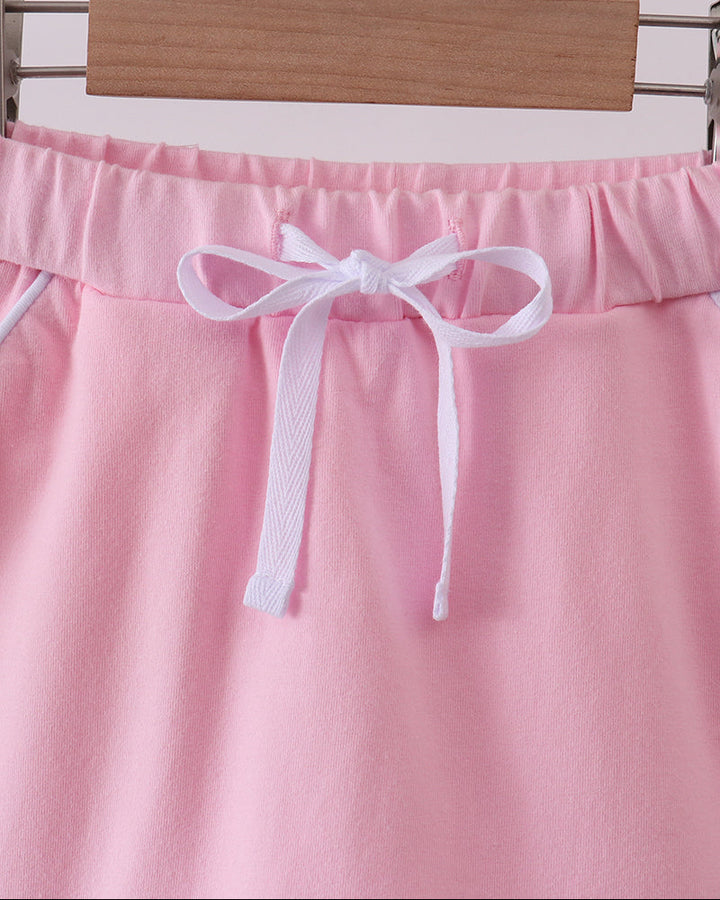 Pink skort with scalloped hem and satin bow at the waistband